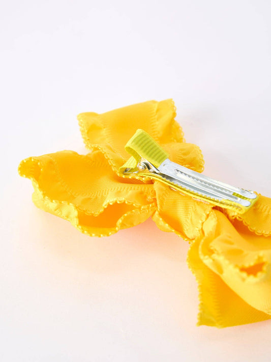 Yellow ruffle bow hair clip showing the alligator clip