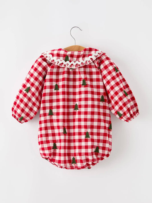 A baby long-sleeve romper in a red and white gingham pattern with small green Christmas tree prints, hanging on a wooden hanger against a plain white background.