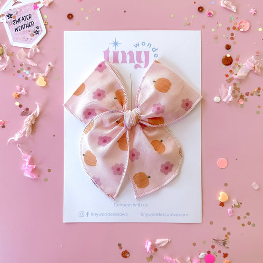 Decorative bow with floral pattern on a pink background with confetti