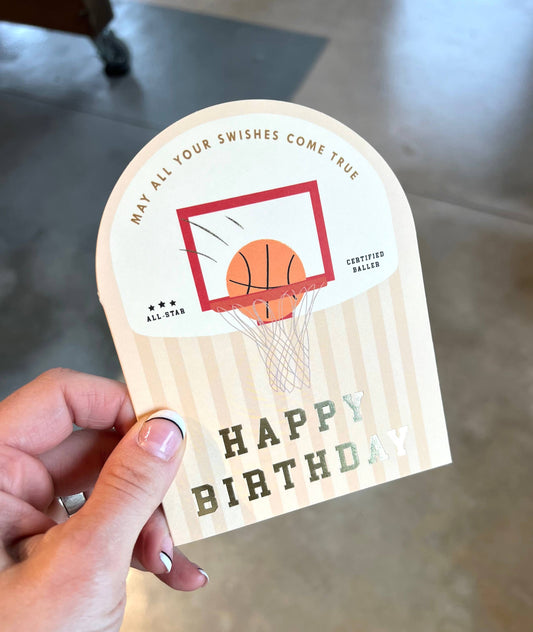 Hand holding a birthday card with basketball design and text.