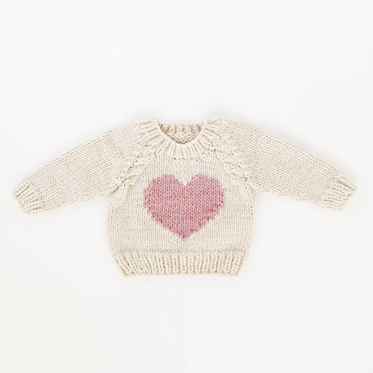 sweetheart hand knit sweater in a natural yarn color. Heart is in a rosy blush color.