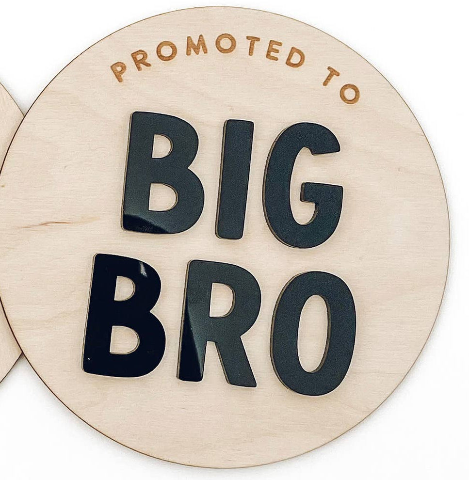 circular wooden sign 'Promoted to Big Bro' on a white background.