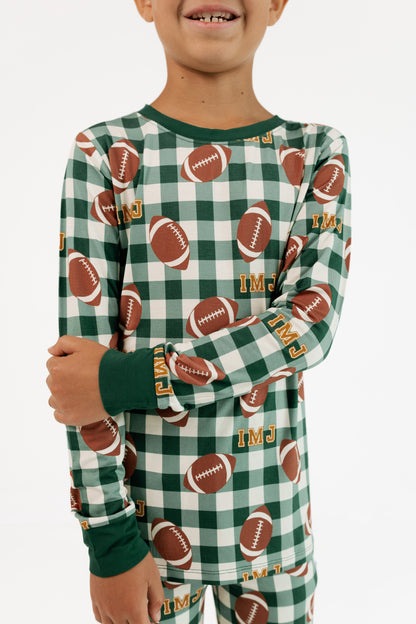 Close up of the Game Day Gingham print showing green plaid with footballs on soft bamboo fabric