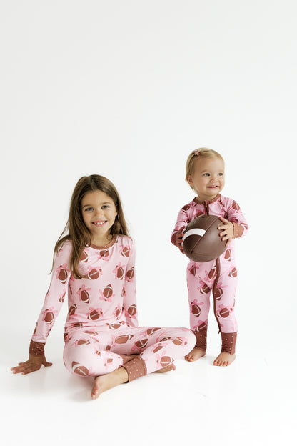 Close up of the Game Day Bows print showing pink footballs and bows on soft bamboo fabric
