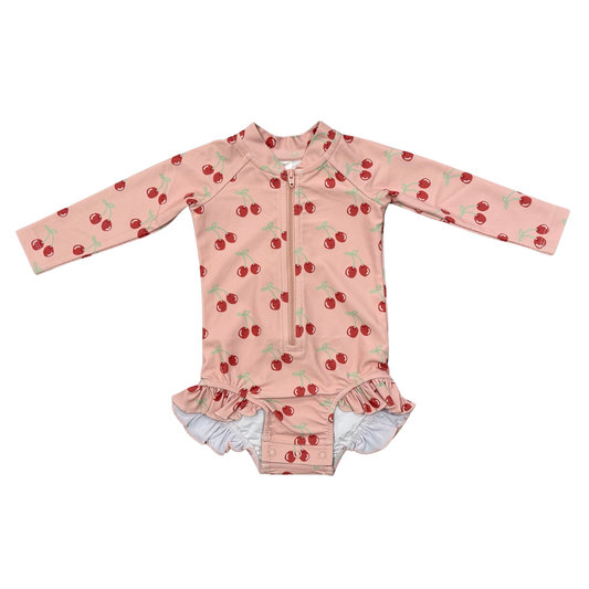 Pink children's swimsuit with cherry pattern on a white background