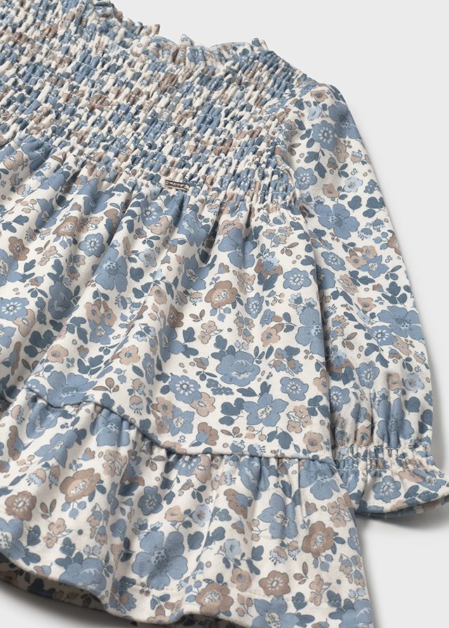 Floral dress with smocked waist and puff sleeves on a white background