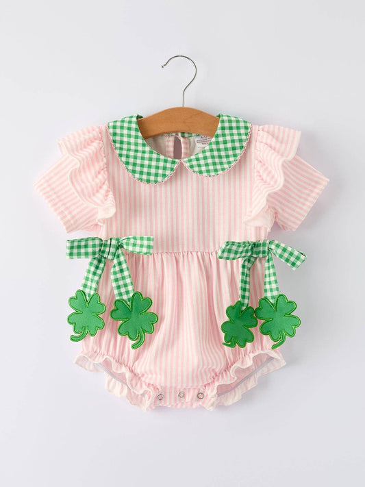Pink baby romper with green checkered collar and shamrock decorations on a white background