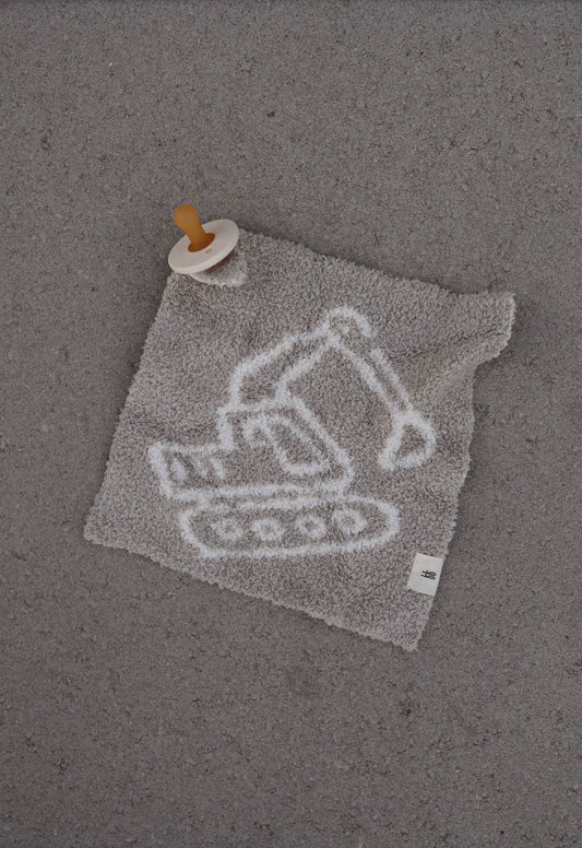 Gray cloth with excavator design and pacifier on a gray background