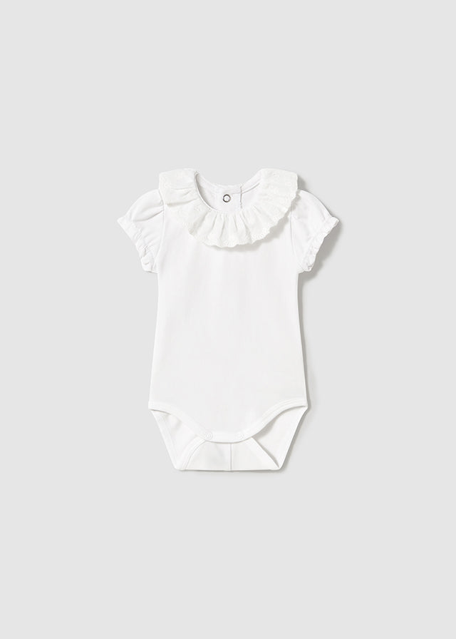 Newborn girl's white ruffled collar bodysuit.