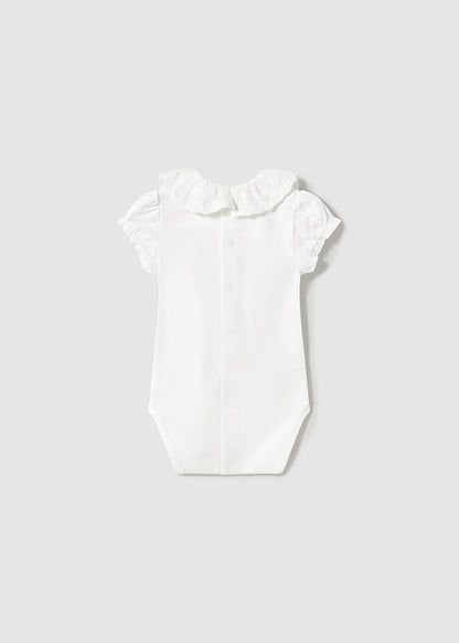 Newborn girl's white ruffled collar bodysuit.