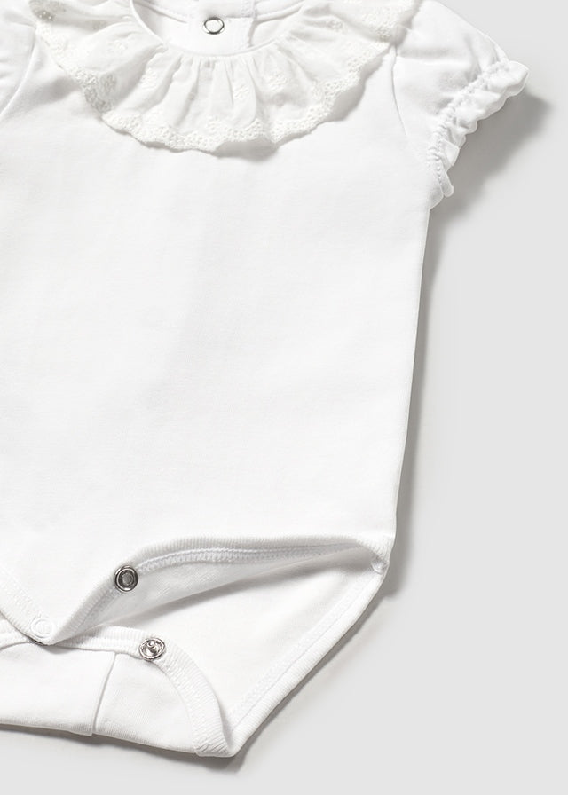 Newborn girl's white ruffled collar bodysuit.