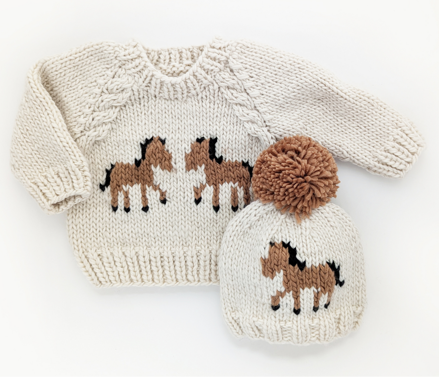Knitted sweater and hat set with horse design on a white background