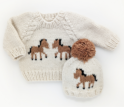 Knitted sweater and hat set with horse design on a white background