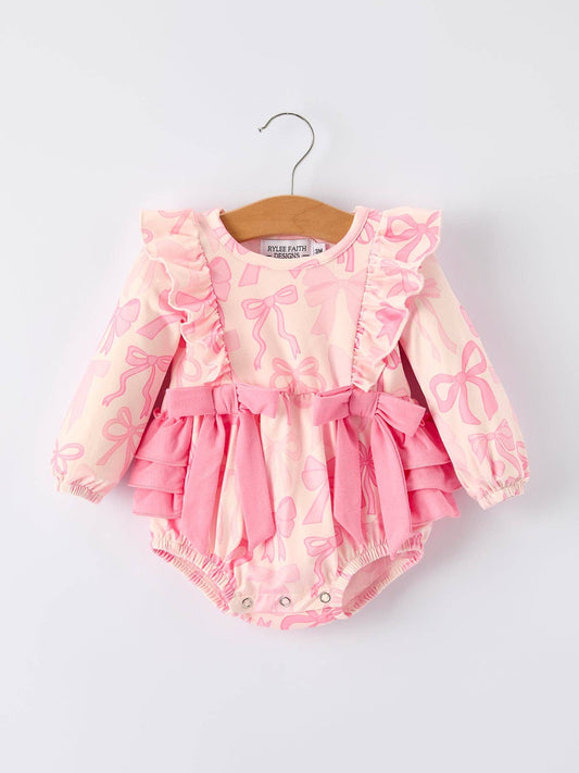 Pink baby romper with ruffles on a hanger against a light gray background