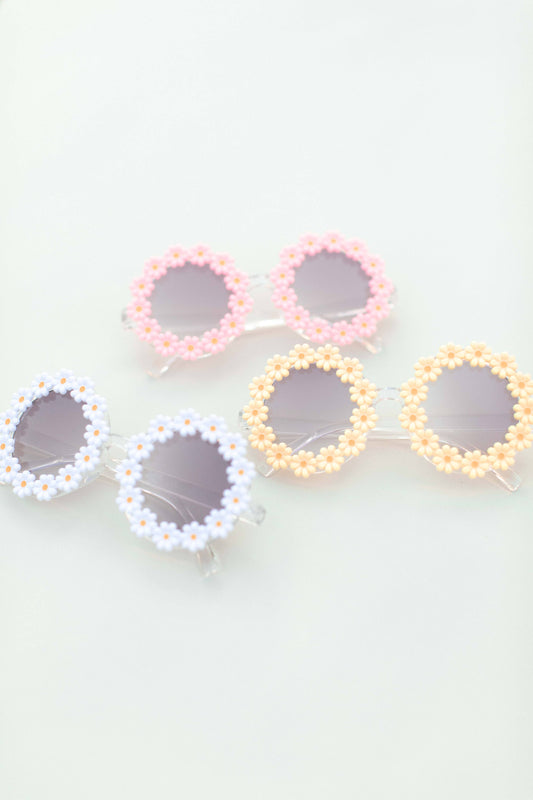 Colorful sunglasses with floral designs on a light background
