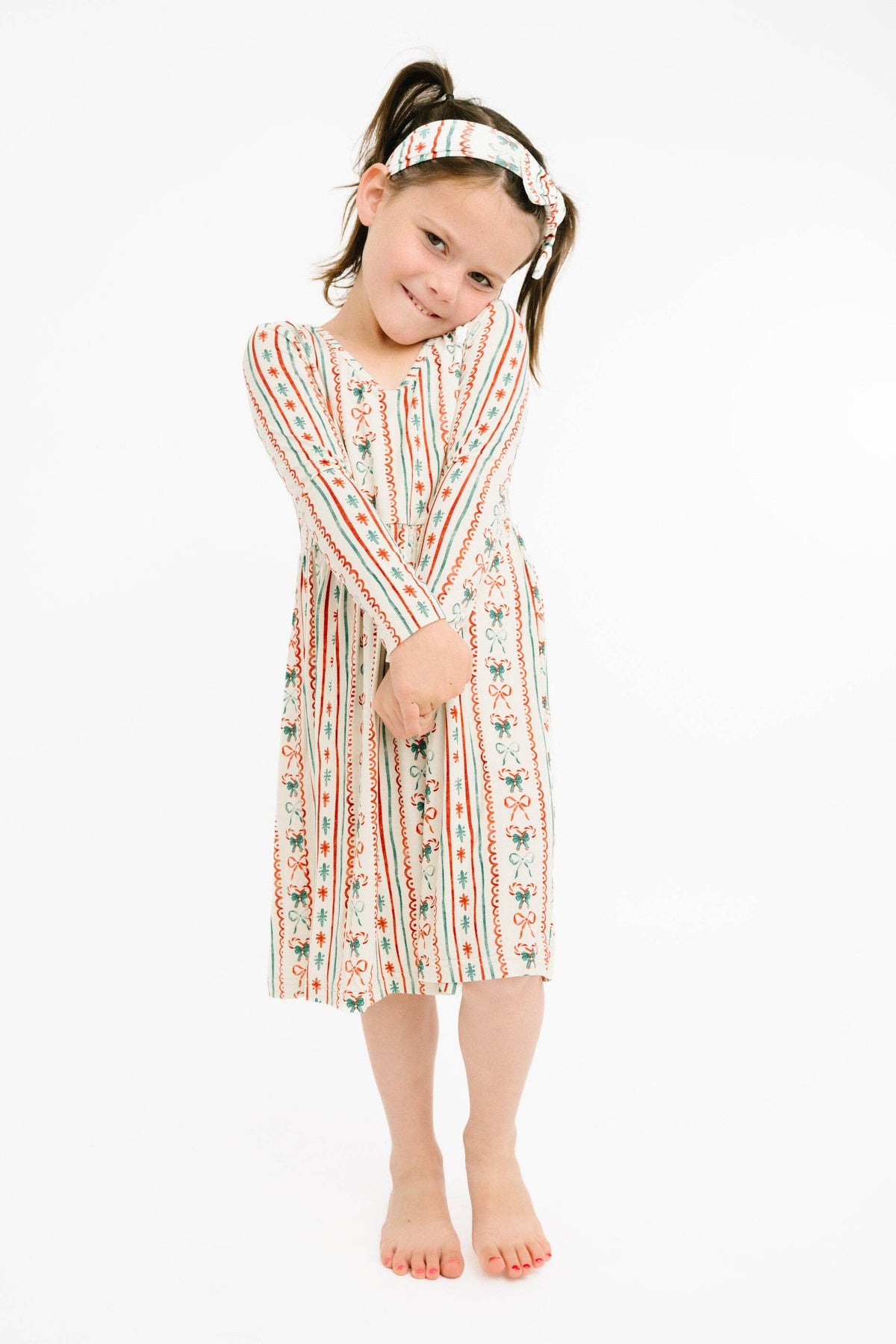 Girl wearing the Christmas Dainty Bow bamboo dress