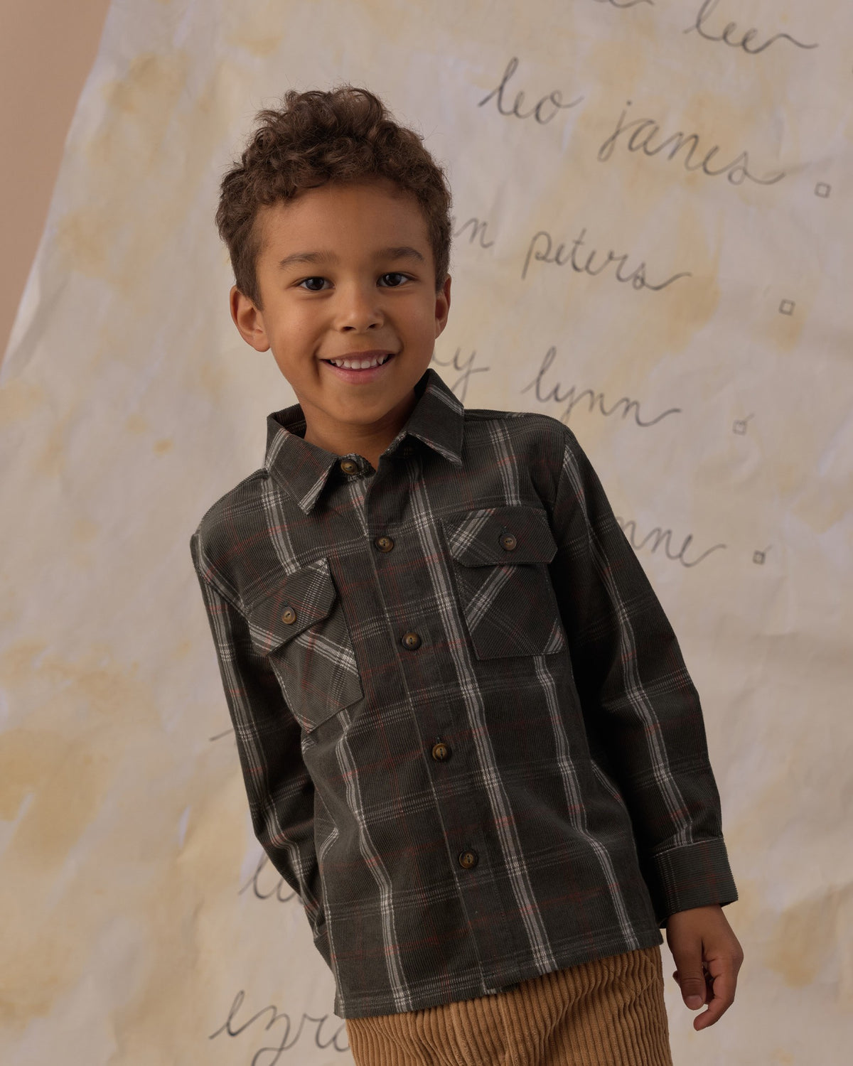 Boy smiling in the Rylee + Cru pocketed flannel shirt in holiday plaid, close view showing the chest pockets