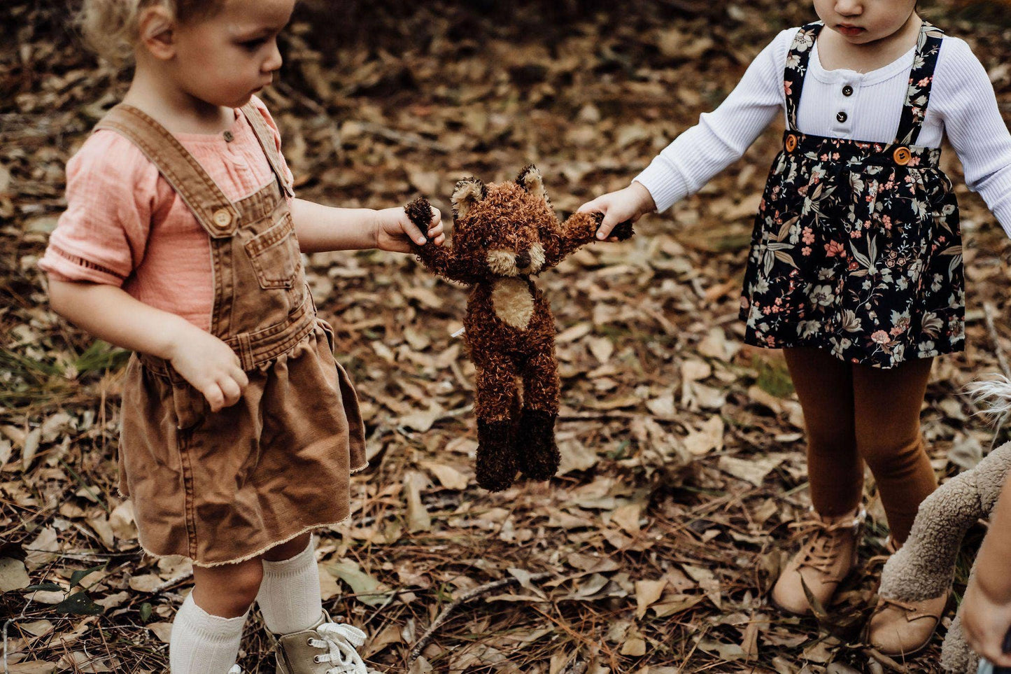 Two children playing with Foxy the Fox in a forest setting