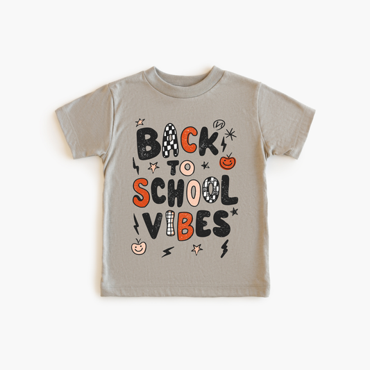 Children's t-shirt with 'Back to School Vibes' text on a beige background