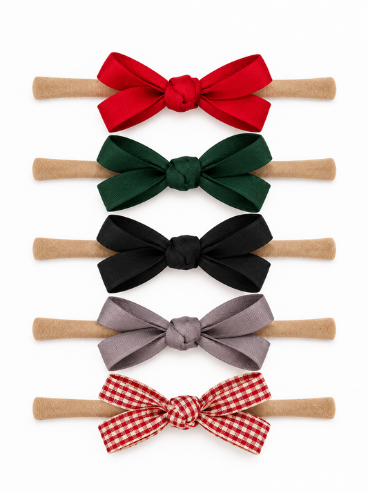 SpearmintLOVE 5-Pack Petite Nylon Bows in Holiday Plaid with red, green, black, gray and plaid bows on nylon bands