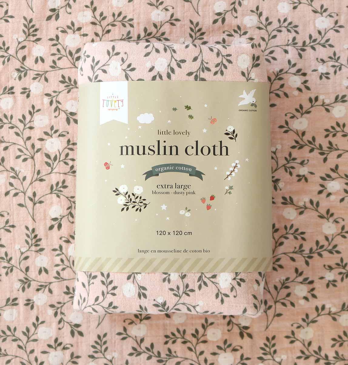 Package of 'little lovely' muslin cloth on a floral patterned background