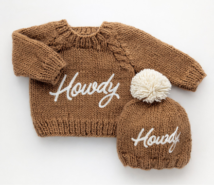 Brown knitted sweater and matching beanie with 'Howdy' text on a white background