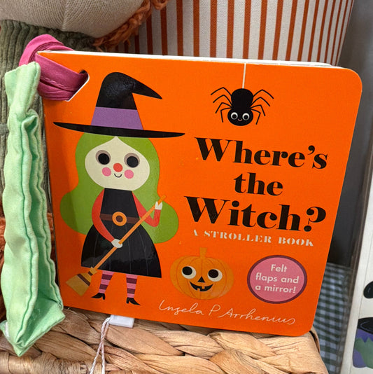 Where's the Witch? A Stroller Book standing on a wooden surface with its green fabric stroller strap