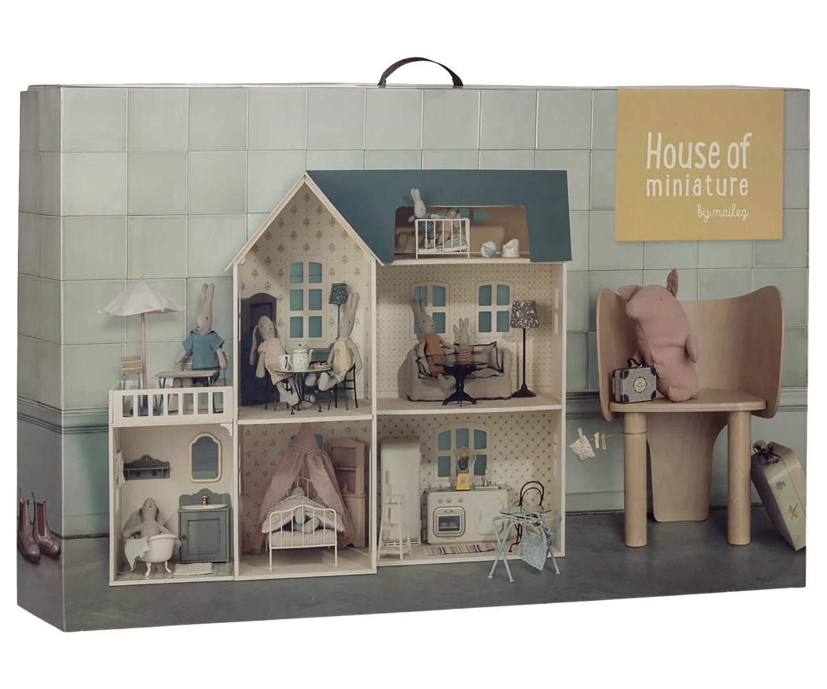 The packaging box for 'House of miniature by Maileg', featuring a detailed illustration of a miniature dollhouse with a wooden chair and a pink plush toy, set against a light green tiled background.