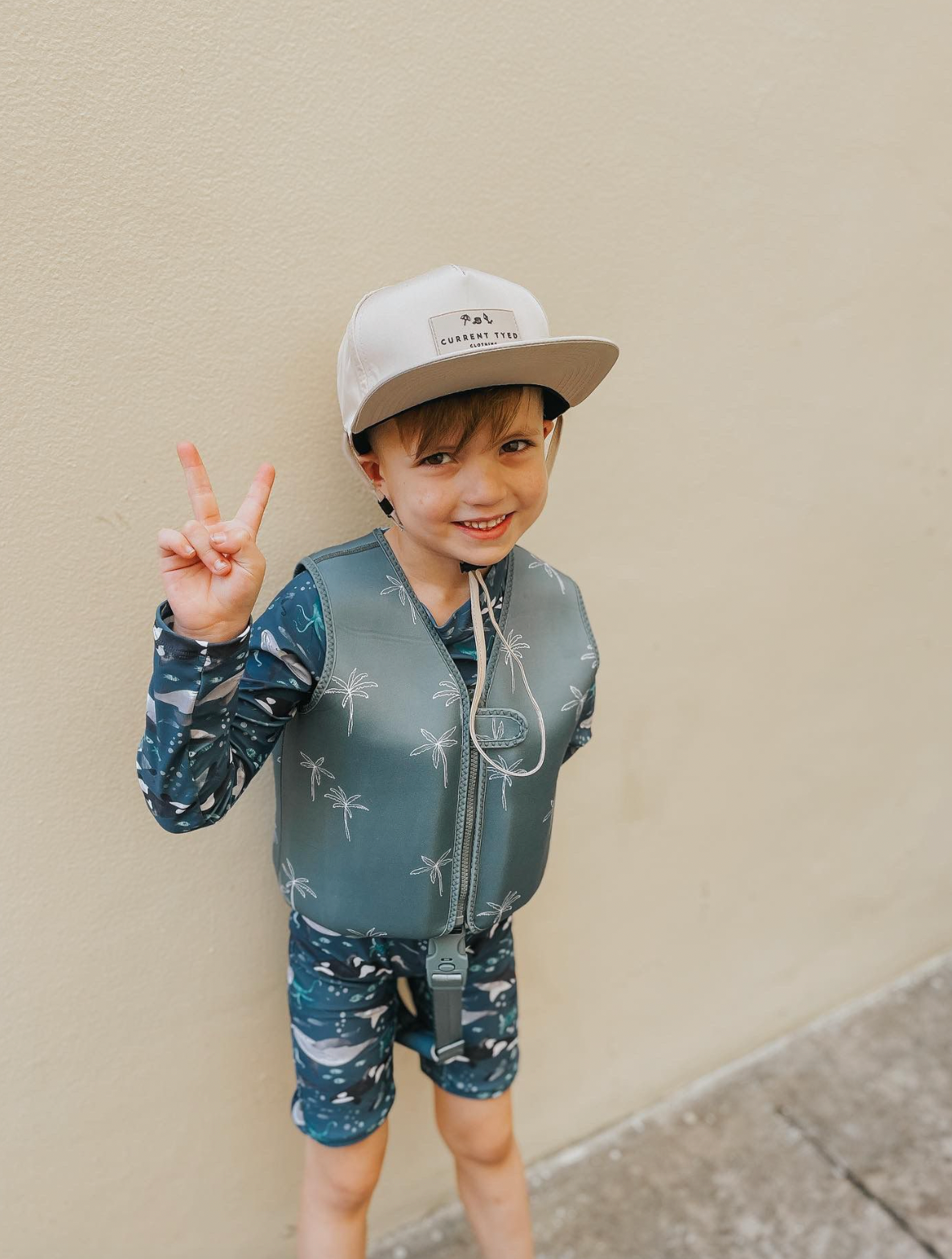 Boy wearing Green palm swim vest