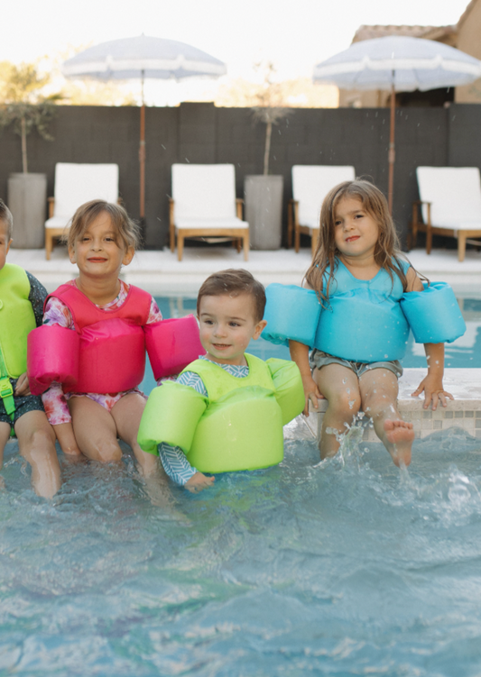 Kids in a pool wearing The "Brights" High Visibility Neon Swim Floaties
