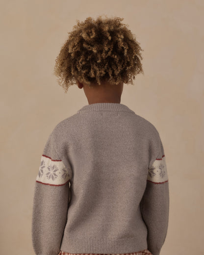 Back of the Rylee + Cru Reagan Apres Ski sweater worn by a child, showing the snowflake bands on the sleeves