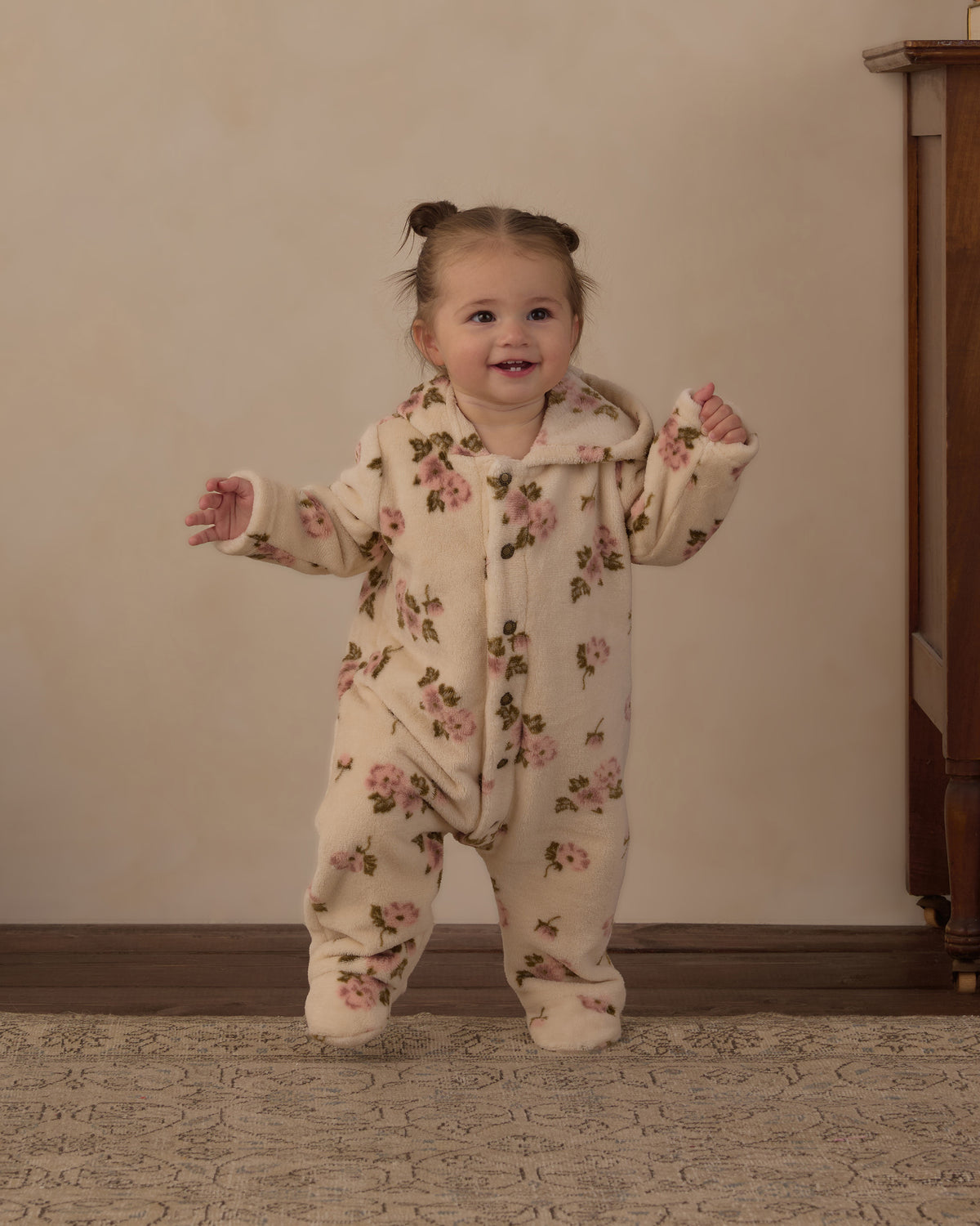 Toddler standing and smiling in the Rylee + Cru Rose Garden fleece jumpsuit