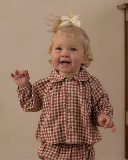 Smiling toddler in the Rylee + Cru Nellie set, brick check top and bloomers