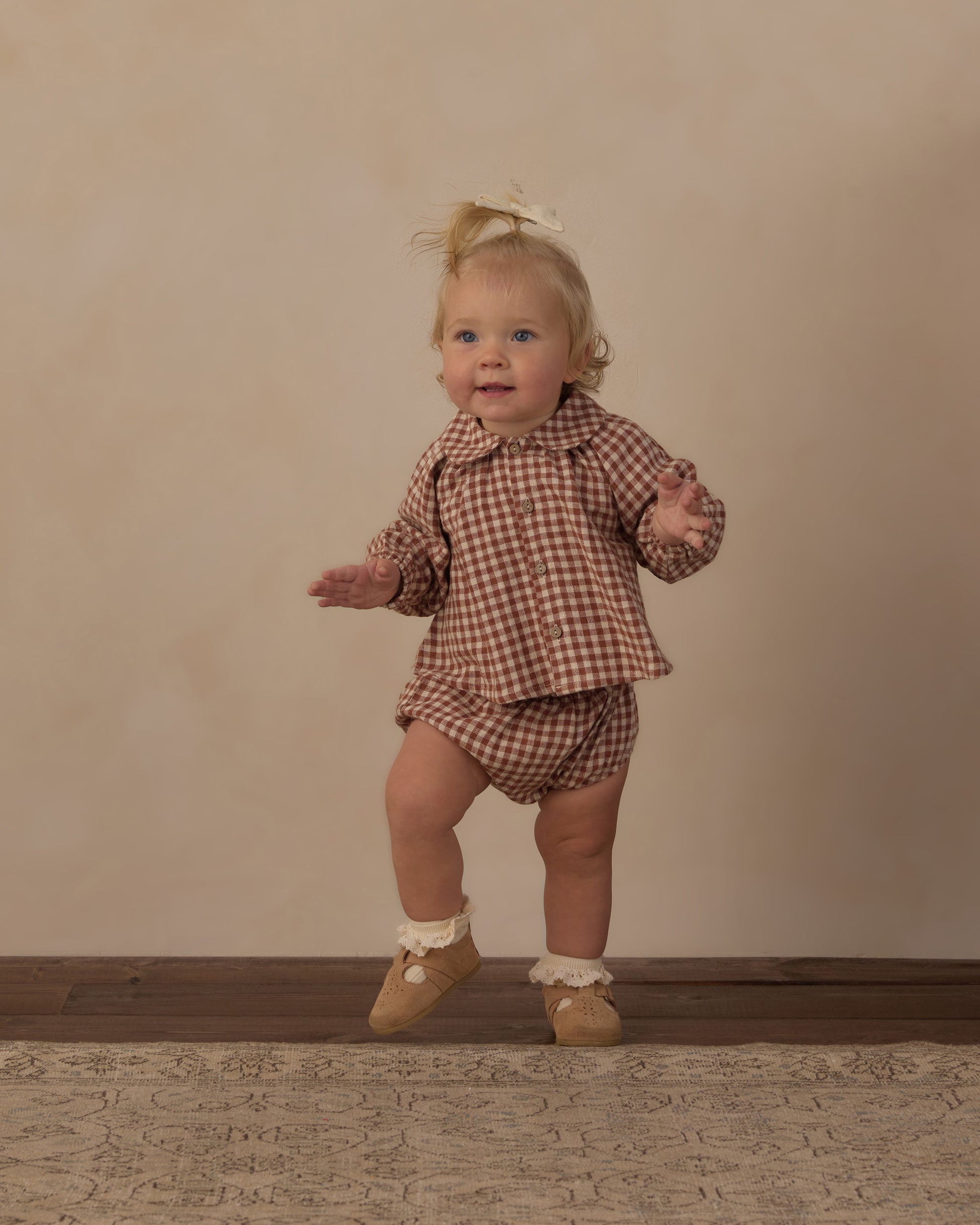 Toddler standing in the brick check Nellie set from Rylee + Cru