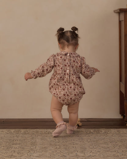 Toddler seen from behind in the Rylee + Cru Cora Romper in pink floral with pink ballet shoes