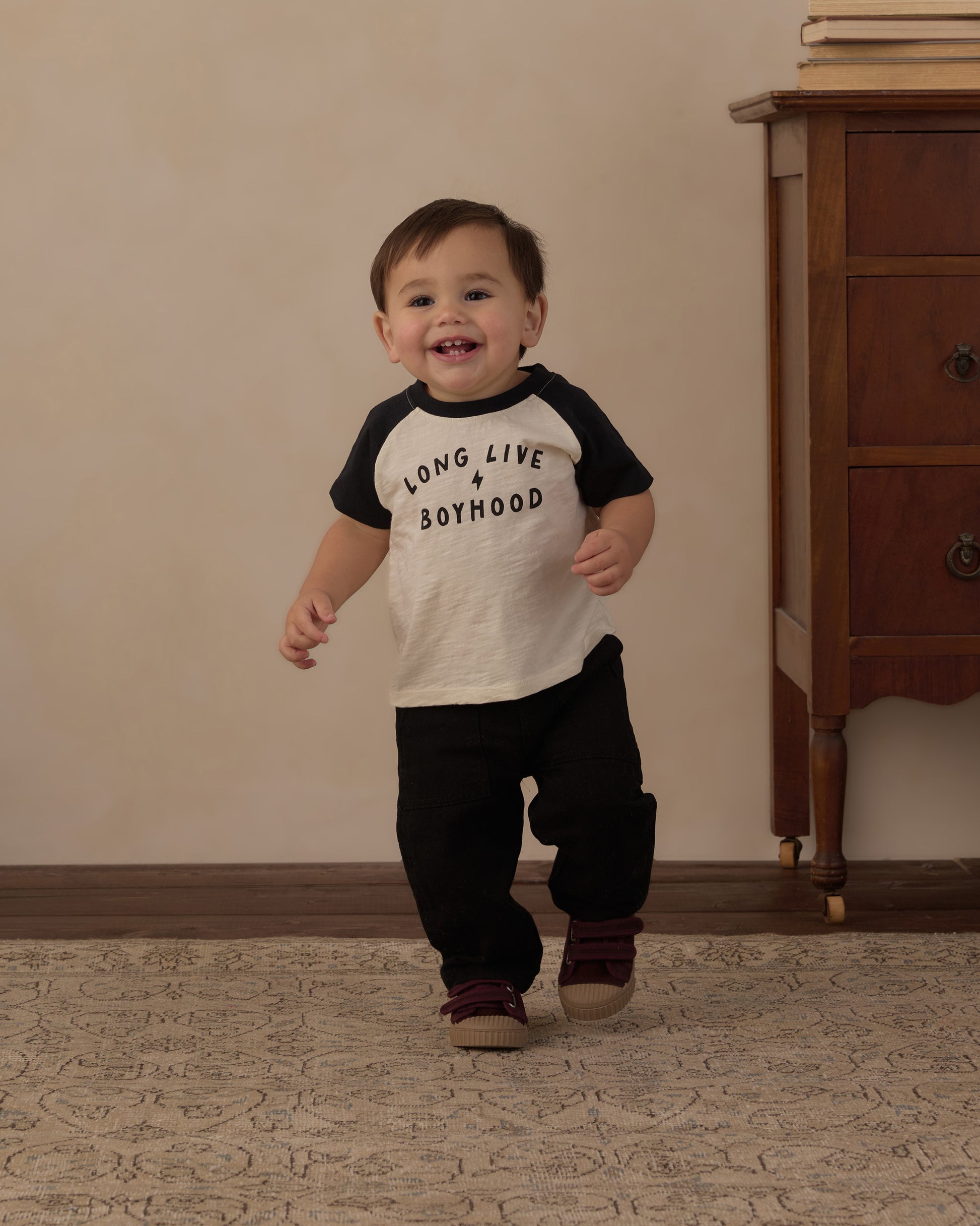 Toddler walking and smiling in the Rylee + Cru Long Live Boyhood raglan tee