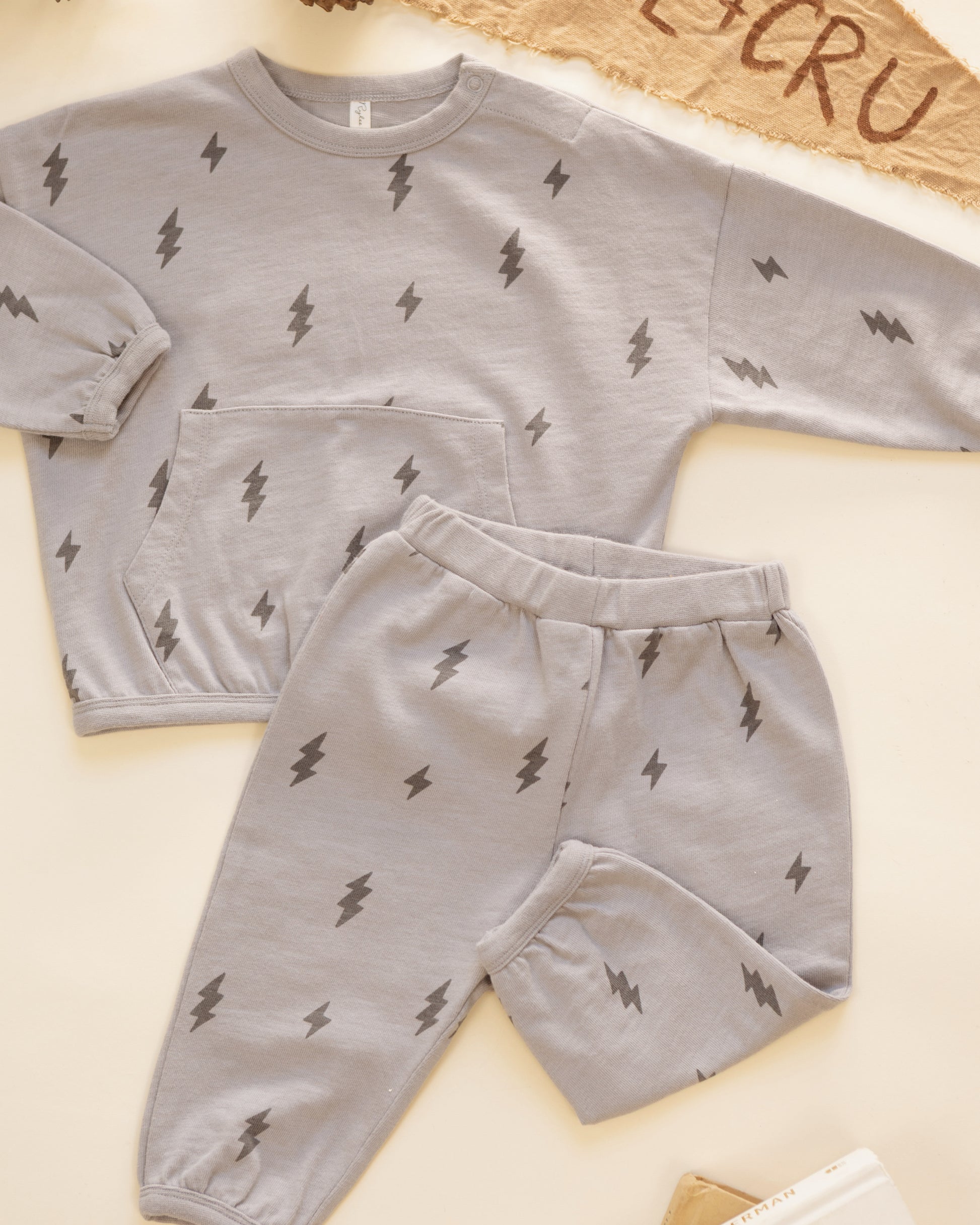Rylee + Cru Relaxed Set in the Bolts print styled flat with a Rylee + Cru pennant and pinecones