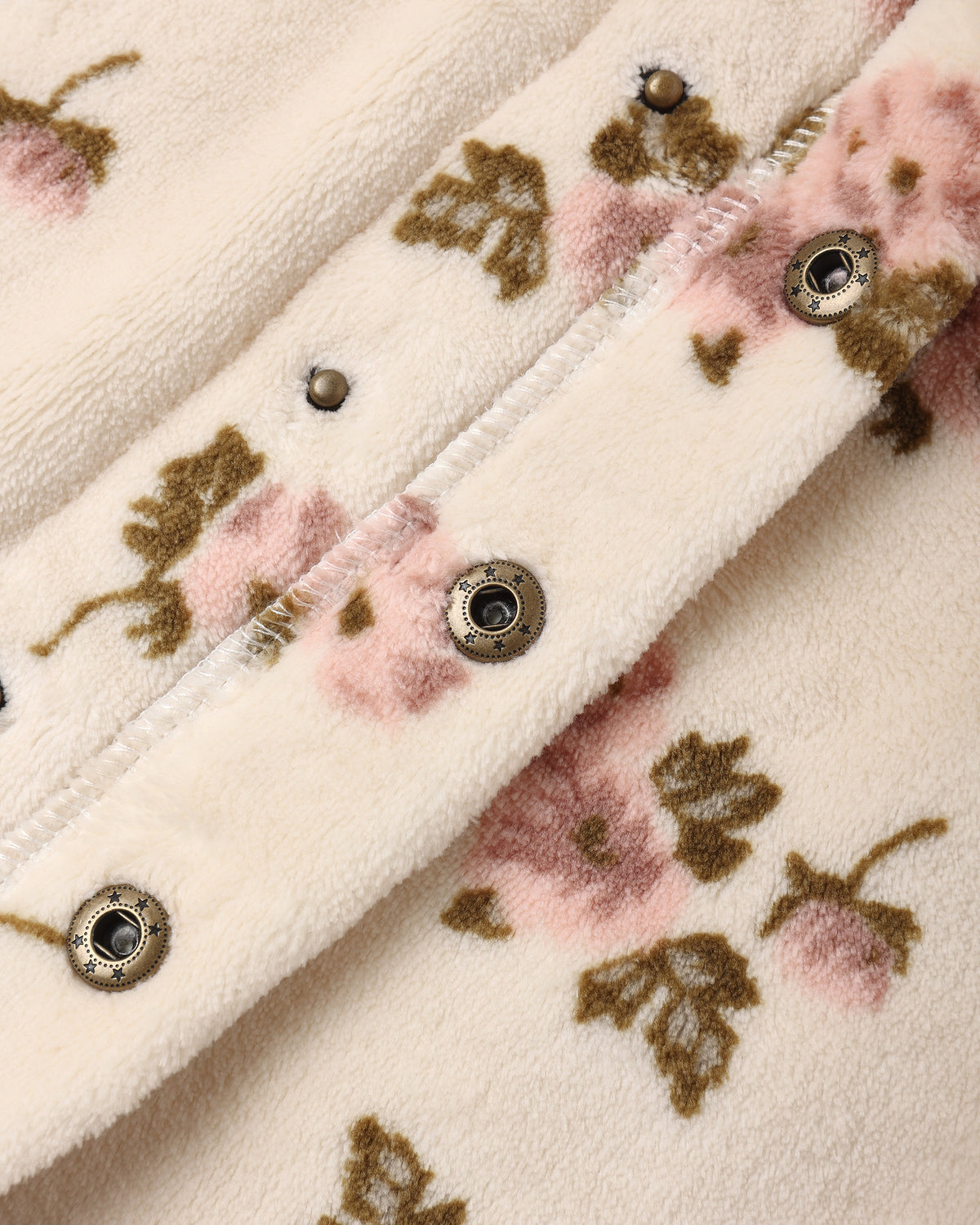 Close view of the embroidered roses and snap placket on the cream Rose Garden fleece