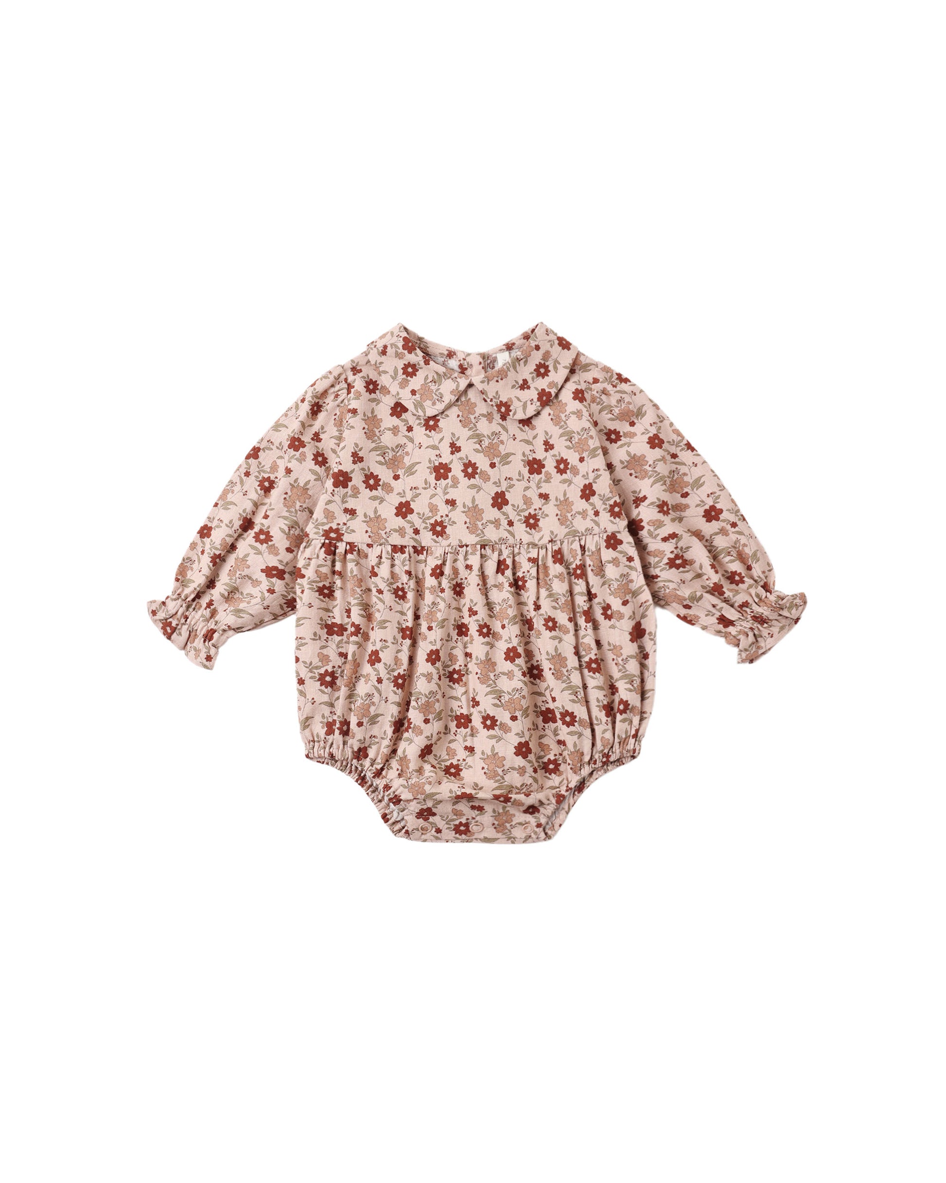 Rylee + Cru Cora Romper in pink floral laid flat, with a Peter Pan collar, smocked chest and elastic leg cuffs