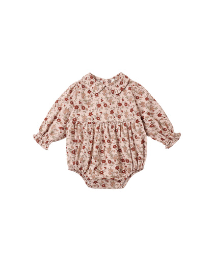 Rylee + Cru Cora Romper in pink floral laid flat, with a Peter Pan collar, smocked chest and elastic leg cuffs