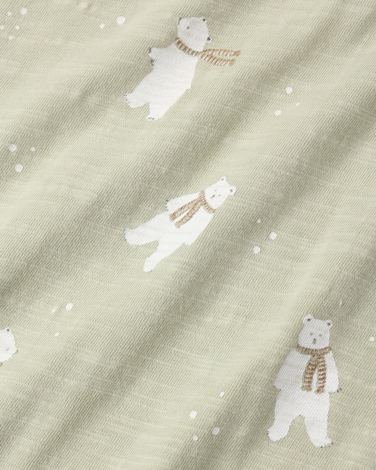 Close view of the Polar Bears print, white bears in scarves on a sage green knit