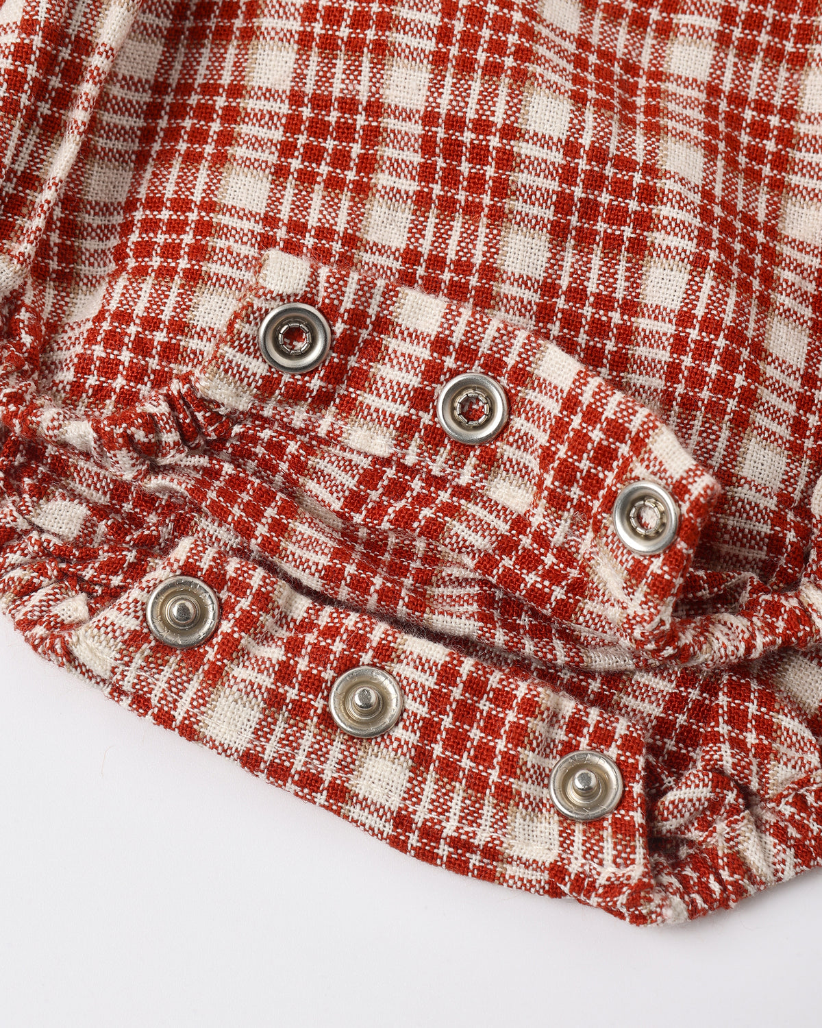 Close view of the snap closures and red plaid fabric on the Rylee + Cru Heidi romper