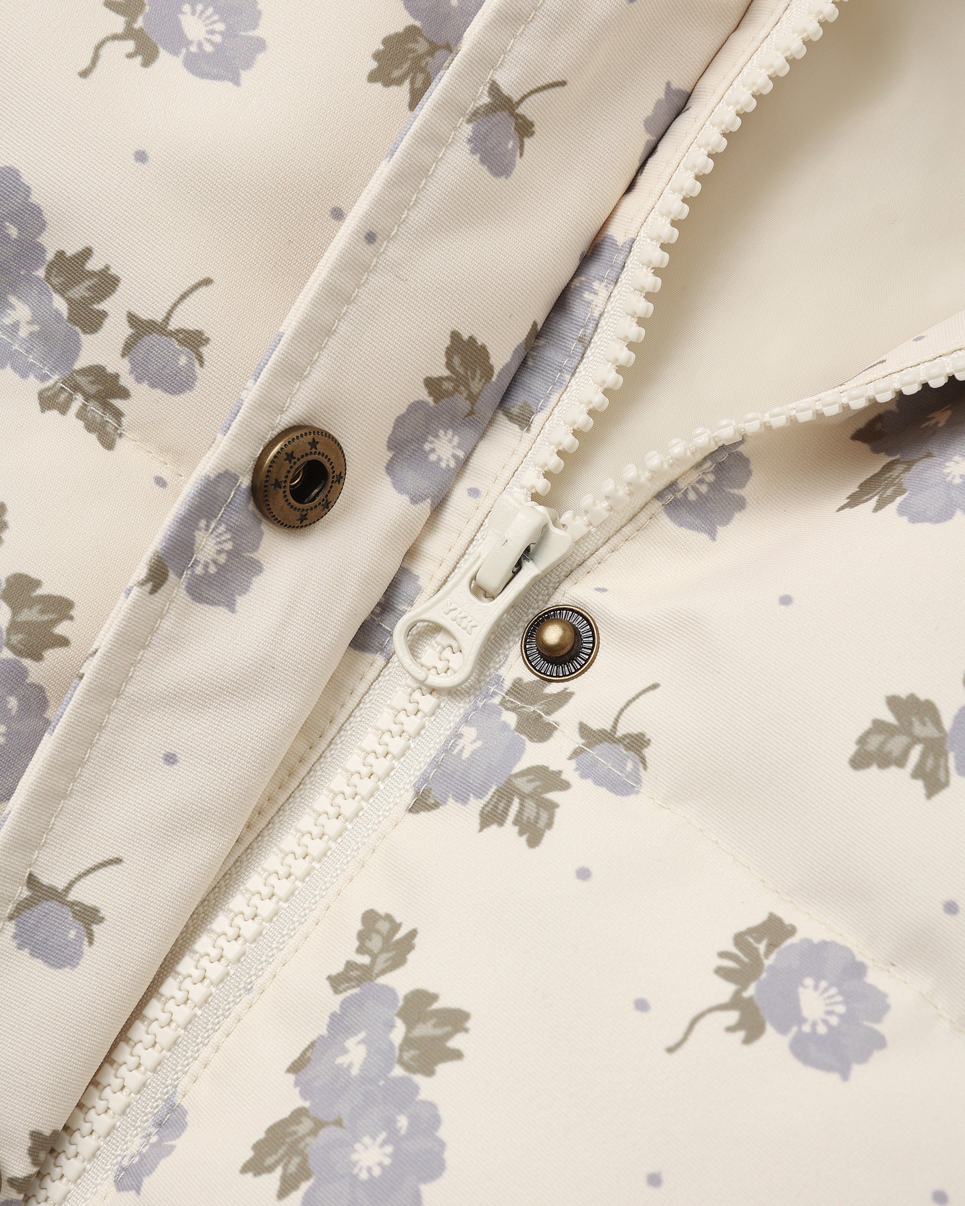 Detail of the Idyllwild Jacket placket with brass snaps and scalloped trim on the blue floral print