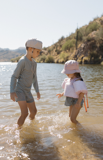 Girl in the water wearing "Sea" You on Top Floaties - Line Rose