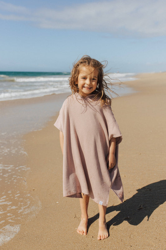 Girl on beach wearing Waffle Beach Poncho - Dusty Rose