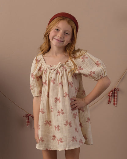 Girl in a red headband posing with a hand on her hip in the Rylee + Cru Sabrina mini dress in peppermint bows