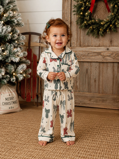 Toddler in the SpearmintLOVE Country Christmas Bows lounge set standing in front of a decorated Christmas tree