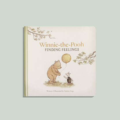 Winnie-the-Pooh: Finding Feelings board book cover, Pooh and Piglet with a yellow balloon in watercolor