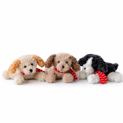 Three plush puppy toys lined up on a white background, each with curly fur in different colors and wearing red striped scarves.