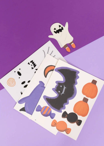 Halloween-themed temporary tattoos on a purple background with a ghost toy.